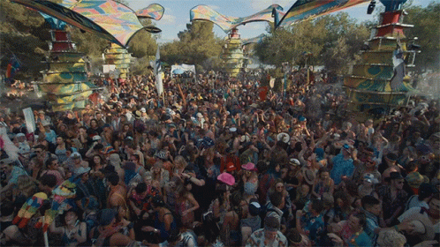 A Large Crowd Of People Are Gathered In A Park With A Sign That Says ' I Love You ' On It GIF