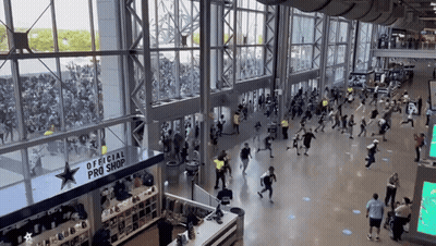 A Large Crowd Of People Are Gathered In Front Of An Official Pro Shop GIF