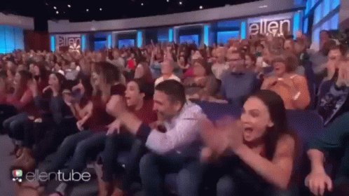 A Large Crowd Of People Are Sitting In A Theater Watching A Show Called Ellentube . GIF