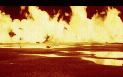 A Large Explosion In A Field With A Puddle In The Middle GIF