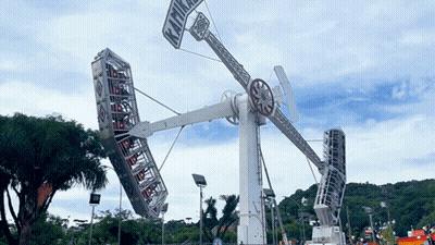 A Large Ferris Wheel With A Sign On It That Says ' Kiwi ' On It GIF
