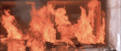A Large Fire Is Burning In A Room With Smoke Coming Out Of It GIF