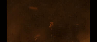 A Large Fire Is Burning In The Dark And A Person Is Standing In Front Of It . GIF
