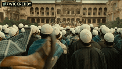 A Large Group Of People Are Gathered In Front Of A Building With A Twitter Username 7Wickreddy GIF