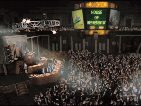 A Large Group Of People Are Gathered In Front Of A Large Screen That Says House Of Representatives GIF