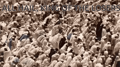 A Large Group Of People Are Kneeling Down In Front Of A Sign That Says All Hail King Of The Losers . GIF