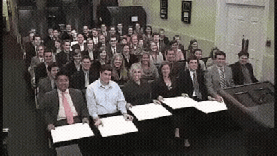 A Large Group Of People Are Posing For A Picture In A Room GIF