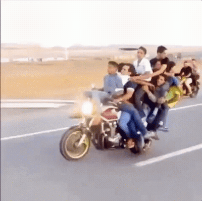 A Large Group Of People Are Riding Motorcycles Down A Road . GIF