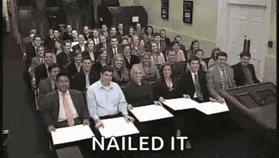 A Large Group Of People Are Sitting At Tables With Papers In Front Of Them And The Words Nailed It Are Above Them . GIF
