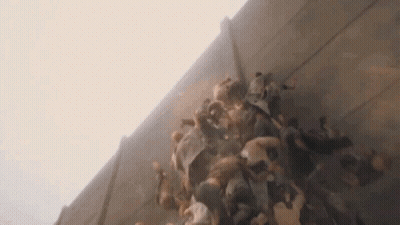 A Large Group Of People Are Standing Next To Each Other Against A Wall . GIF