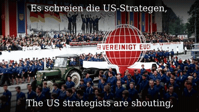 A Large Group Of People Marching In Front Of A Sign That Says Vereinigt Euc GIF