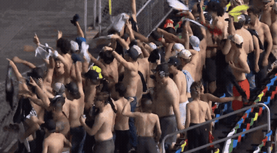 A Large Group Of People Without Shirts Are Gathered In A Stadium GIF