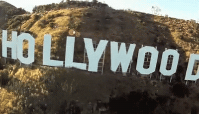 A Large Hollywood Sign Is Sitting On Top Of A Hill GIF
