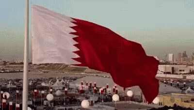 A Large Red And White Flag Flies In The Wind GIF