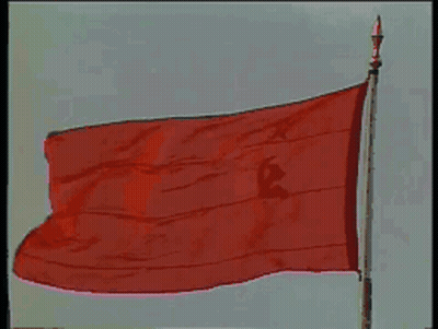 A Large Red Flag With A Hammer And Sickle On It Is Flying In The Wind GIF