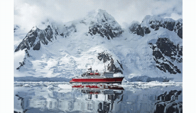 A Large Red Ship Is Floating In The Water In Front Of Snow Covered Mountains GIF