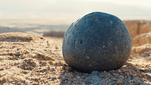 A Large Rock Is Sitting On Top Of A Pile Of Dirt GIF