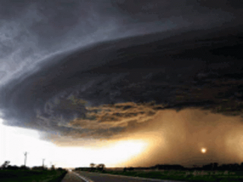 A Large Storm Cloud Is Moving Over A Highway GIF