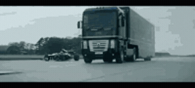 A Large Truck Is Driving Down A Road With A Motorcycle In The Background . GIF