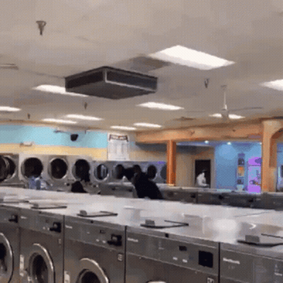 A Laundromat With Lots Of Washers And Dryers And A Sign That Says No Pets GIF