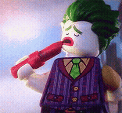 A Lego Figure Of The Joker Is Holding A Red Lipstick In His Mouth GIF
