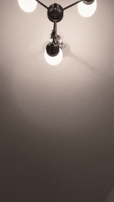 A Light Hanging From The Ceiling With Three Lights On It GIF