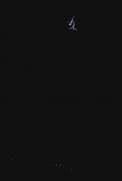 A Lightning Bolt Is Visible In The Sky Above A City GIF