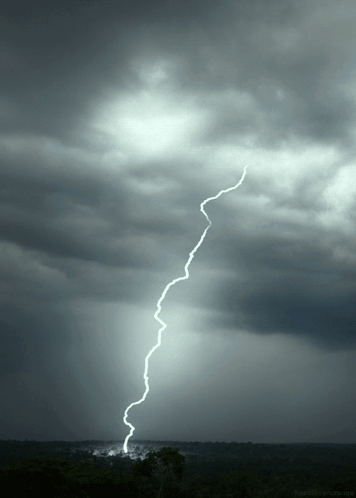 A Lightning Bolt Strikes The Ground In A Dark Sky GIF