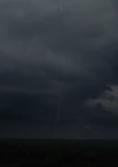 A Lightning Bolt Strikes The Ground In The Middle Of The Field GIF