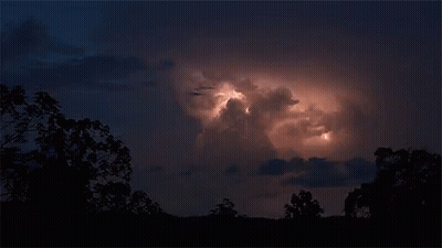A Lightning Strike Is Visible In The Dark Sky GIF