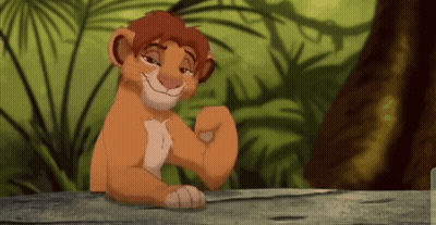 A Lion Cub From The Lion King Is Sitting On A Wooden Table . GIF