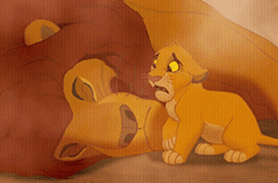 A Lion Cub Laying On Top Of A Lion GIF