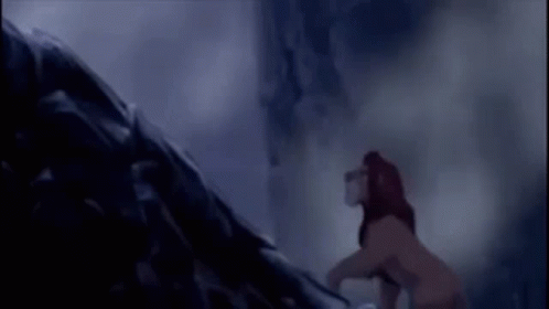 A Lion Is Standing On Top Of A Rock In A Dark Cave . GIF