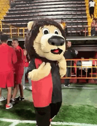 A Lion Mascot Is Standing On A Football Field In Front Of A Crowd . GIF