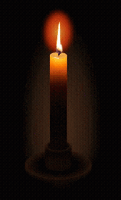 A Lit Candle In A Dark Room With A Candle Holder GIF