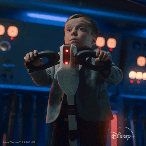 A Little Boy Holding A Steering Wheel With The Words What Is That Below Him GIF