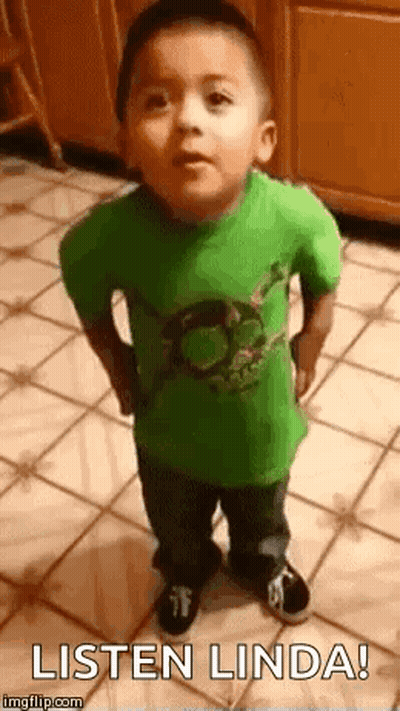 A Little Boy In A Green Shirt Is Standing On A Tiled Floor And Making A Funny Face . GIF