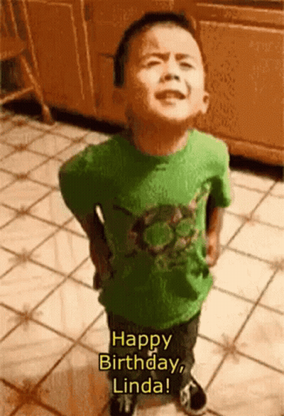 A Little Boy In A Green Shirt Is Standing On A Tiled Floor And Saying Happy Birthday Linda GIF