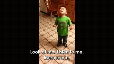 A Little Boy In A Green Shirt Is Standing On A Tiled Floor And Says Look At Me Listen To Me Listen To Me GIF