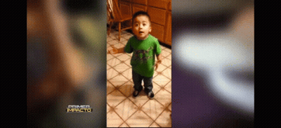 A Little Boy In A Green Shirt Is Standing On A Tiled Floor . GIF