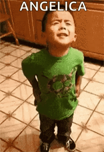 A Little Boy In A Green Shirt Is Standing On A Tiled Floor With The Name Angelica On The Bottom . GIF
