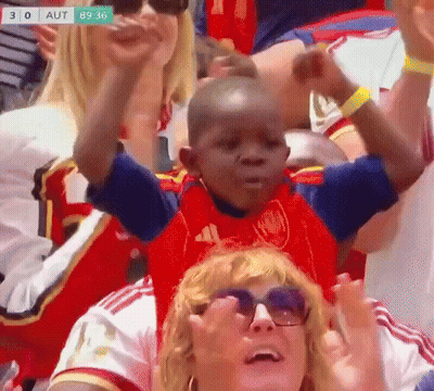 A Little Boy In A Red Adidas Shirt Is Sitting On A Woman 'S Shoulders GIF