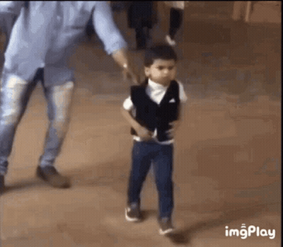 A Little Boy In A Suit Is Walking With His Father . GIF