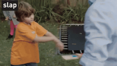 A Little Boy In An Orange Shirt Is Being Slapped By A Man In A Blue Shirt .. GIF