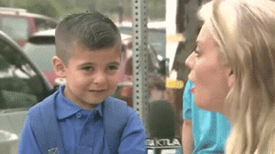 A Little Boy Is Being Interviewed By A Woman With A Microphone That Says Ktla On It GIF