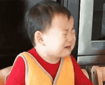 A Little Boy Is Crying In Front Of A Microwave . GIF