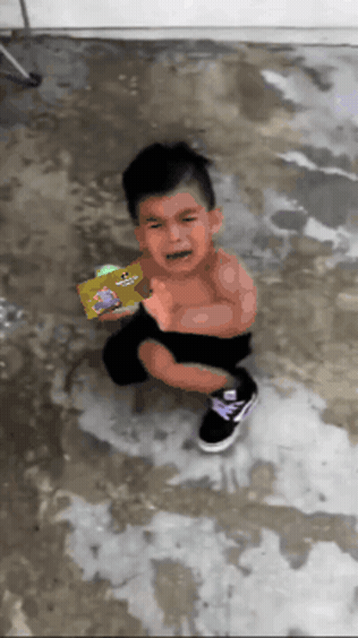 A Little Boy Is Crying While Holding A Book That Has A Picture Of A Dog On It GIF
