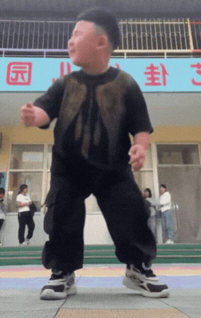 A Little Boy Is Dancing In Front Of A Sign That Says ' S ' On It GIF
