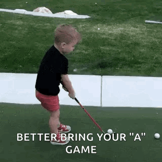 A Little Boy Is Playing Golf On A Green And Holding A Golf Club . GIF
