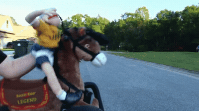 A Little Boy Is Riding A Rockin Rider Legend Toy Horse GIF